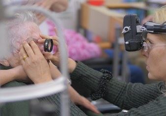 בדיקת עיניים לקשישה באמצעות עדשה ואור חזית