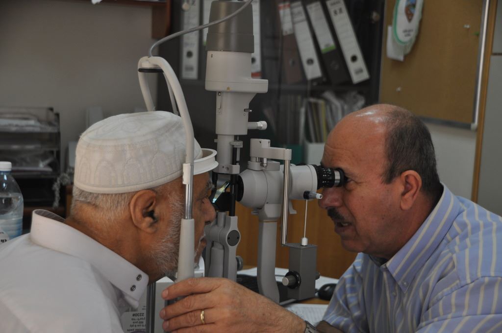 רופא עיניים בודק מטופל מבוגר במרפאה